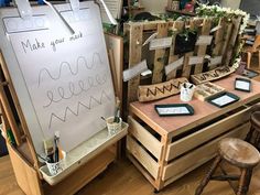 a whiteboard with writing on it sitting next to some wooden crates and stools