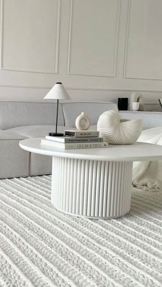 a white coffee table sitting on top of a carpeted floor next to a couch