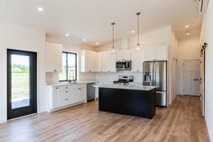 an empty kitchen with white cabinets and black counter tops is seen in this image from the doorway