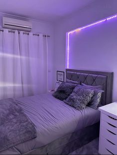 a bedroom with purple lighting and a bed