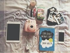 there are many items that can be found on the bed, including an ipod, camera and books