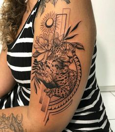 a woman with a tattoo on her arm has a cheetah and flowers on it