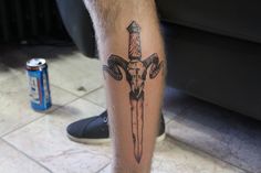 a man's leg with a tattoo on it and a can of soda in the background