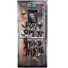 graffiti on the side of a metal door that says don't open dead inside