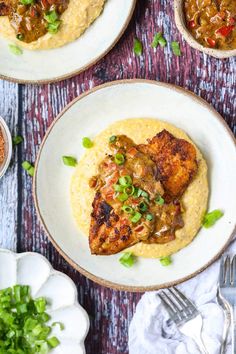 two white plates topped with chicken chops and mashed potatoes, garnished with green onions