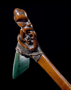 a wooden carving on top of a piece of wood with a knife blade sticking out of it