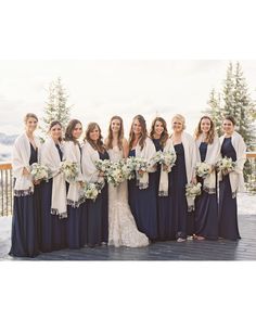 a group of women standing next to each other on top of a snow covered ground