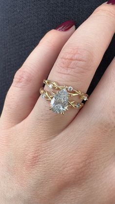 a woman's hand with a ring on it and two diamonds in the middle