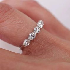 a woman's hand with a diamond ring on top of her finger, showing the band