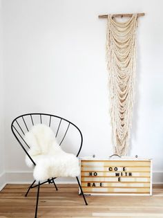 a white chair sitting next to a wooden box on top of a hard wood floor