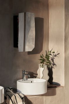 a white sink sitting under a mirror next to a wall mounted towel dispenser