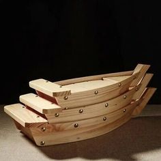 four wooden boats stacked on top of each other in front of a black background,