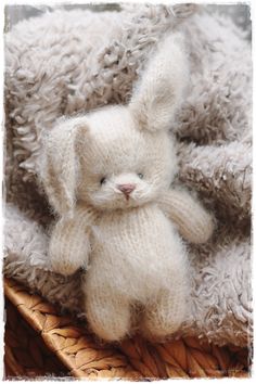 a white stuffed animal sitting on top of a blanket