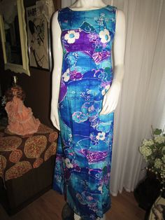 "ALOHA!! I have a 1960's beautiful tropical/floral print sleeveless, ankle length dress for your Hawaiian days. Dress has a scoop front neckline, slightly low back with nylon zipper, empire top of dress, with a slight two pleat train/drape look in back waist area. Dress has a size 10 tag, by Ui-Maikal of Hawaii, with colors of teal/dark/royal blue, white, purple/fushia, pink, olive, and black, cotton fabric. Bust 43\", Waist 28\", Armholes 15\", Length 54\", in excellent condition. PRICE IS $75. Sleeveless Maxi Dress With Hibiscus Print, Sleeveless Hawaiian Maxi Dress With Tropical Print, Area Dress, Empire Top, Dark Royal Blue, Black Cotton Fabric, Pink Olive, Ankle Length Dress, Tropical Floral Print