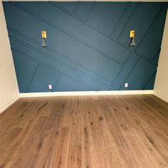 an empty room with blue walls and wood floors in the foreground, there is no one on the floor