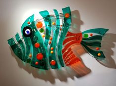 a glass fish sculpture is shown on the wall