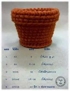 an orange crocheted basket sitting on top of a white table next to a ruler