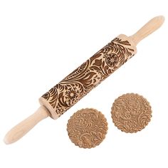 a wooden rolling pin with two matching wood discs in the middle and an intricately carved design on each side