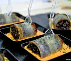 some food is sitting on trays with forks in them and ready to be eaten