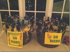 two buckets filled with beer bottles sitting on top of a table next to a window