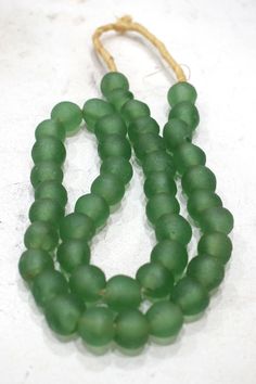 three strands of green beads on a white surface