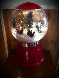 a red snow globe sitting on top of a wooden table