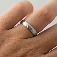 a close up of a person's hand with a wedding ring on their finger