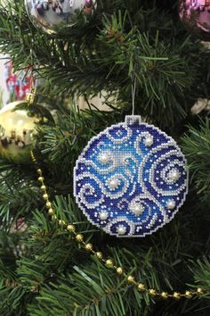 a blue ornament hanging from a christmas tree