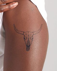 a close up of a person with a tattoo on their arm and the bottom half of her leg