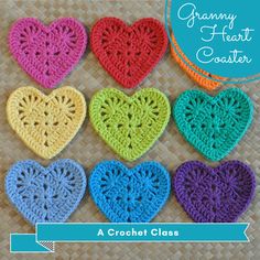 six crocheted hearts arranged in different colors on a woven tablecloth with wicker background