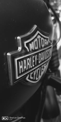 black and white photograph of harley davidson logo on the back of a motorcycle's headlight