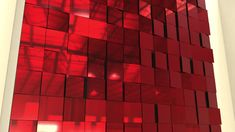 a red wall that is made up of squares and rectangles with light coming through it