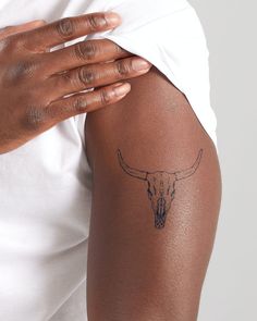 a person with a tattoo on their arm holding onto his elbow and wearing a white t - shirt