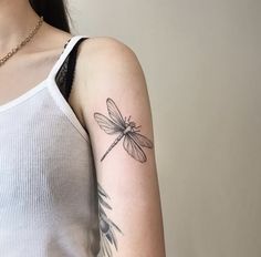 a woman with a dragonfly tattoo on her arm