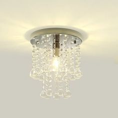 a chandelier hanging from the ceiling in a room with white walls and flooring