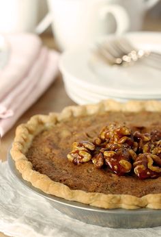 a pie sitting on top of a metal pan covered in nuts