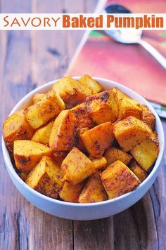 a white bowl filled with baked pumpkins on top of a wooden table