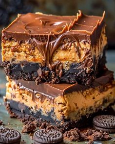 three chocolate peanut butter bars stacked on top of each other with oreo cookies around them