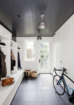 a bike is parked in front of a white door and some shelves with clothes on them