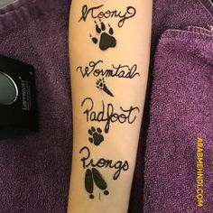 a person with a tattoo on their arm that has writing on it and paw prints