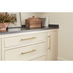 a white dresser with drawers and a wooden box on top