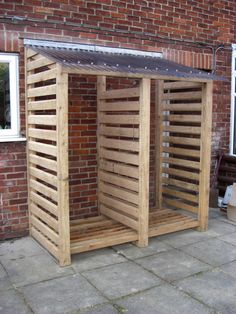 a wooden structure sitting on the side of a brick building next to a white door