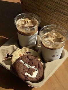 three cups of coffee and two cookies on a table