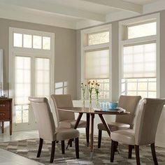 a dinning room table with four chairs and a bowl of flowers on the table