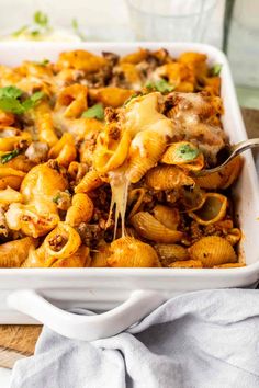 a white casserole dish filled with pasta and meat