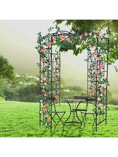 an outdoor table and chairs set up in the grass with pink flowers on it's arbor