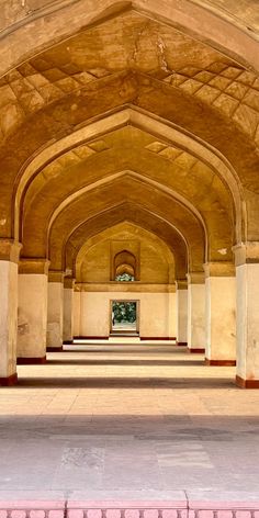 the inside of an old building with columns and arches on both sides, looking towards the front door