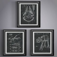 three framed drawings on the wall in front of a gray wall with two black frames