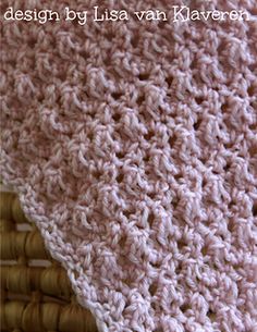 a crocheted blanket is laying on a wicker basket