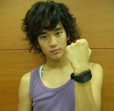 a young man in a tank top posing for the camera with his hand on his hip